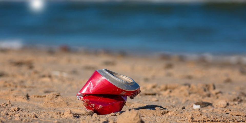 Wird beim Plogging aufgesammelt: Zerbeulte alte Coladose am Strand