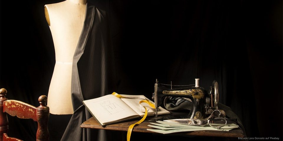 Atelier eines Änderungsschneiders, mit Puppe, Tisch, Nähmaschine und Buch.