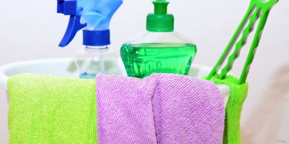 Spülmittel, Glasreiniger und Microfasertücher in einem Putzeimer